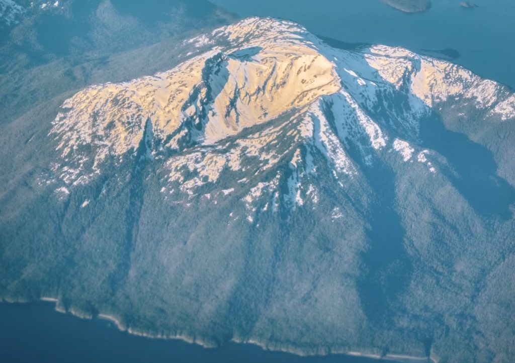 view of Alaska mountain range from the window seat of an airplane